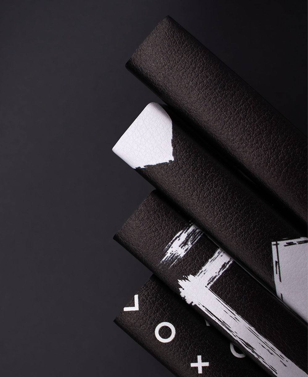 The spines of 4 black and white notebooks showing the fine grain vegan leather quality